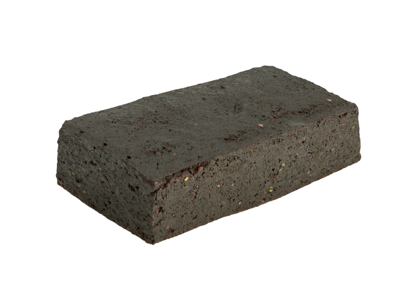 Close-up of a dark rectangular Blueberry Lavender CBN Fruit Bites bar with visible flecks of fruit and herb pieces.