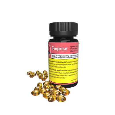 Black bottle of Emprise Light Year THC softgels with a pink label, beside a pile of loose amber softgel capsules.