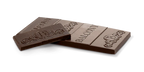 Two broken pieces of the 65% Dark Chocolate CBD Cannatonic Bar, showing the embossed Balcony logo and scroll pattern on the chocolate.