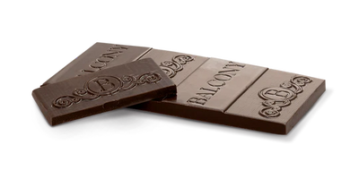 Two broken pieces of the 65% Dark Chocolate CBD Cannatonic Bar, showing the embossed Balcony logo and scroll pattern on the chocolate.