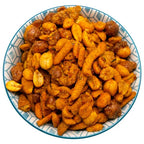 Bowl of Astroid-Mix seasoned snack mix featuring peanuts, corn nuts, and other legumes coated in an orange spice blend.