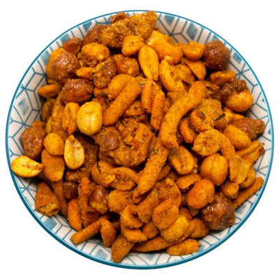 Bowl of Astroid-Mix seasoned snack mix featuring peanuts, corn nuts, and other legumes coated in an orange spice blend.