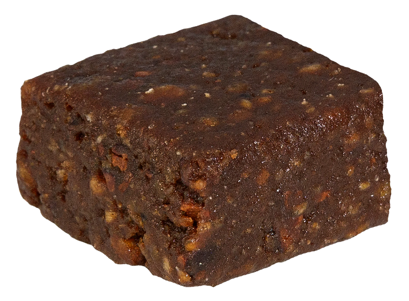 Close-up of a single dark chocolate-coated fruit bite square with a textured, fudge-like surface.