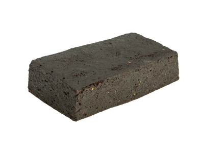 Close-up of a dark rectangular Blueberry Lavender CBN Fruit Bites bar with visible flecks of fruit and herb pieces.