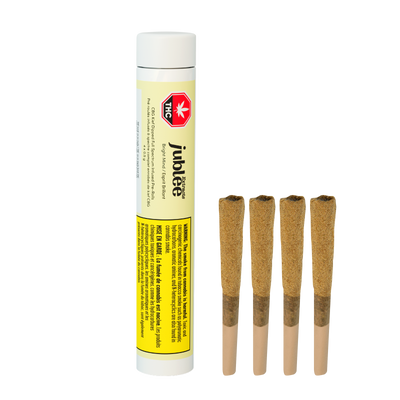 White tube labeled Jublee Extracts Bright Mind CBG Kief Dipped pre-rolls beside four kief-dipped pre-rolled joints.