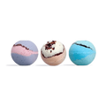 Three round bath bombs in a row: purple and pink swirl, cream with dark red flecks, and blue and teal swirl