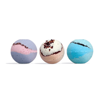 Three round bath bombs in a row: purple and pink swirl, cream with dark red flecks, and blue and teal swirl