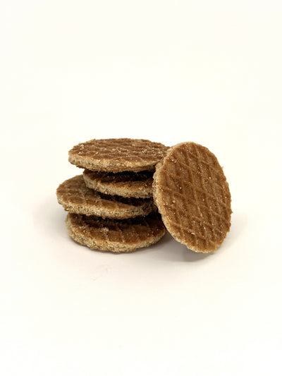 Stack of round waffle-textured caramel stroopwafel bites with one piece leaning against the stack.