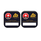 Two Four Buds Farms tin lids side by side, labeled Cookiez N Cream Bubble Hash and Gorilla Zkittlez Bubble Hash.