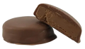 Two round chocolate-coated bites, one whole and one halved showing a soft hazelnut filling inside