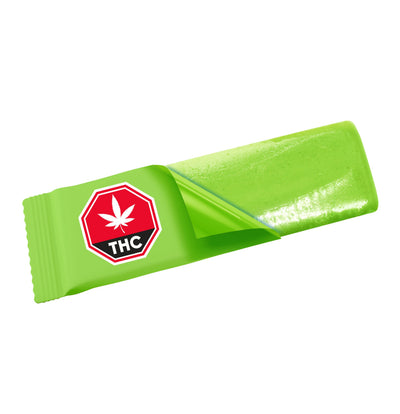Individually wrapped green watermelon-flavoured chewy candy partly unwrapped, revealing the light green candy piece and THC symbol on the wrapper.