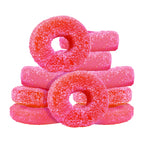 Stacked pile of sugar-coated pink and red sour watermelon gummy rings.