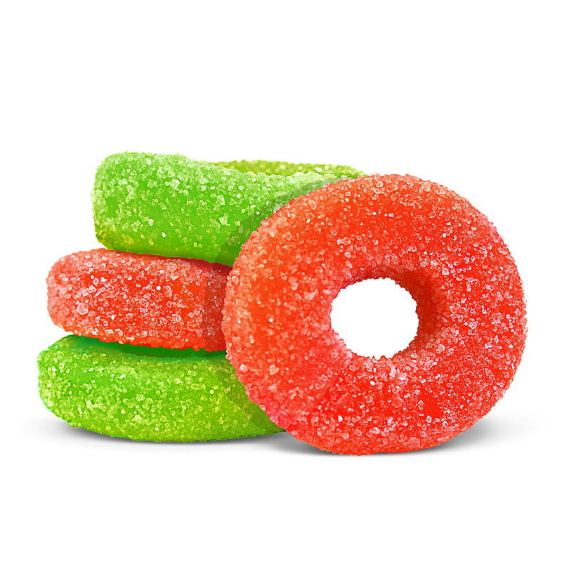 Sugar-coated red and green ring-shaped gummies stacked together on a black background.