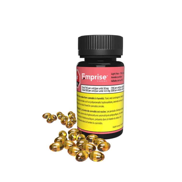 Black bottle of Emprise Light Year THC softgels with a pink label, beside a pile of loose amber softgel capsules.