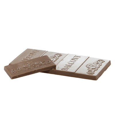 Two milk chocolate squares embossed with the Balcony logo and lettering, one flipped to show its underside.