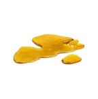 Irregular chunk of translucent amber shatter concentrate on a white background.