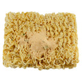 Block of dried ramen-style noodles topped with a mound of seasoning powder, viewed from above.