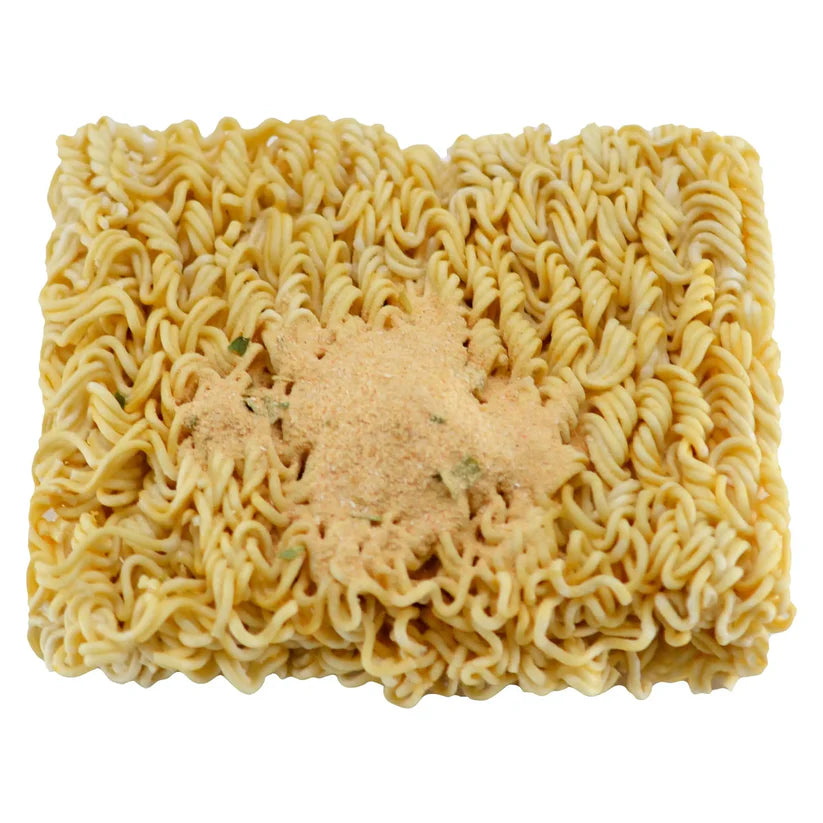 Block of dried ramen-style noodles topped with a mound of seasoning powder, viewed from above.