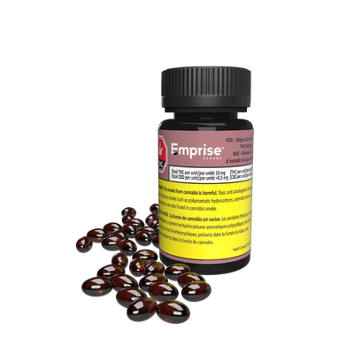 Amber glass bottle labeled Emprise VCE Virgin Cannabis Extract THC Softgels beside a pile of dark red softgel capsules.